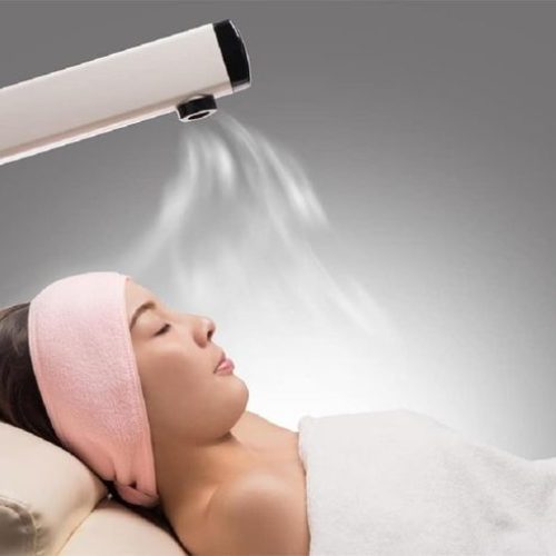 Beauty treatment of face skin with ozone facial steamer in spa center , asian women facing the steam. Steam for smooth skin